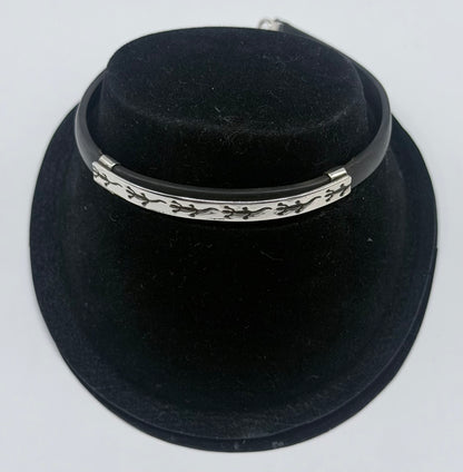 Pulsera de plata .925 y caucho negro con figura de iguana en cierre, vista frontal sobre maniquí