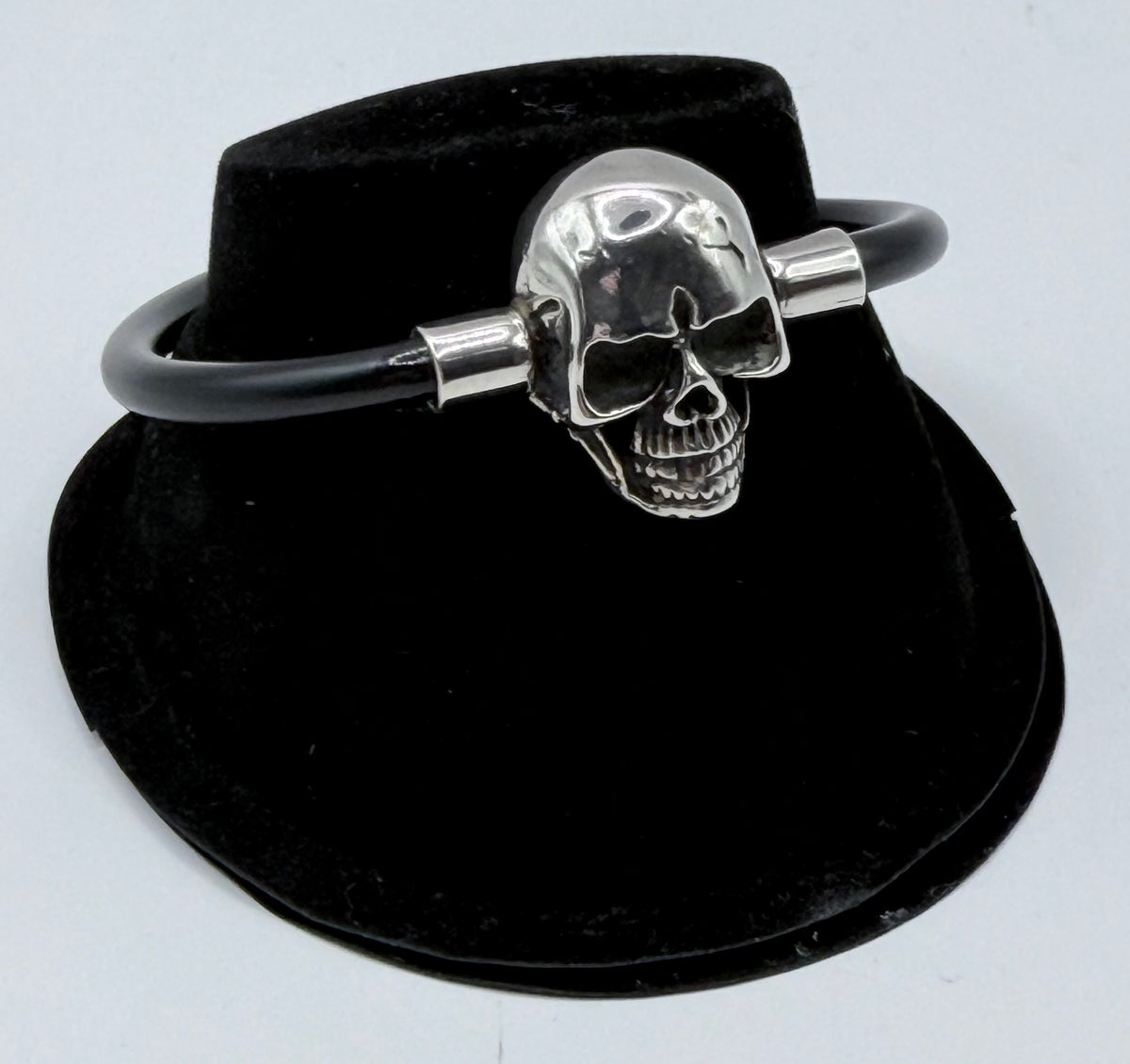 Pulsera de calavera en plata .925 con correa de caucho negro, vista frontal del dije