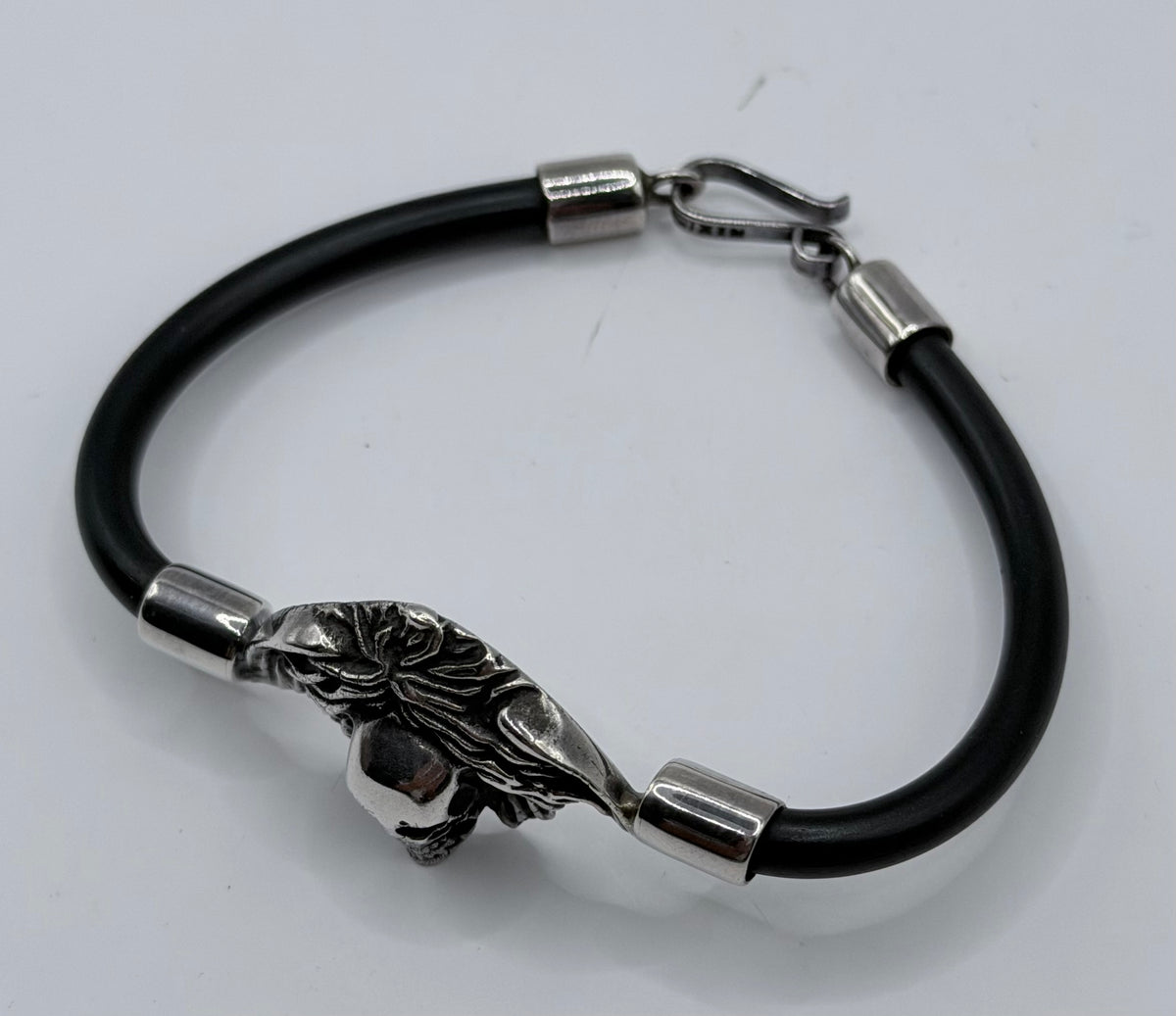 Detalle lateral de la pulsera de calavera mostrando el cierre seguro y la correa de caucho